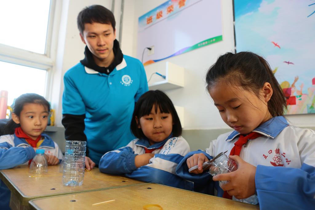 物理学院学生指导小学生制作回滚筒